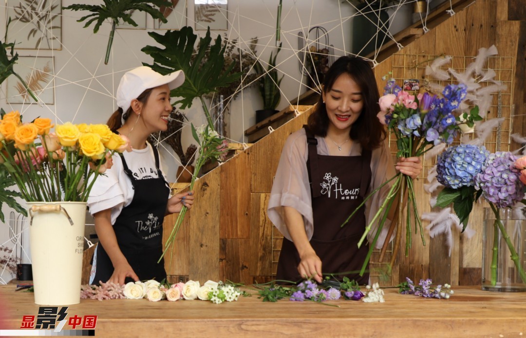 “昆明是鮮花的原產(chǎn)地，有亞洲最大的鮮切花交易市場，可以說具備開花店的天時地利；另外和很多女孩一樣，我從小也就有開花店的夢想！”說起當(dāng)初的決定，王黎媛說一是因為夢想，另外也跟昆明這個城市產(chǎn)花、賣花的“基因”有關(guān)。圖為王黎媛和同事在制作花束。新華網(wǎng) 周亞平/攝 念新洪/文